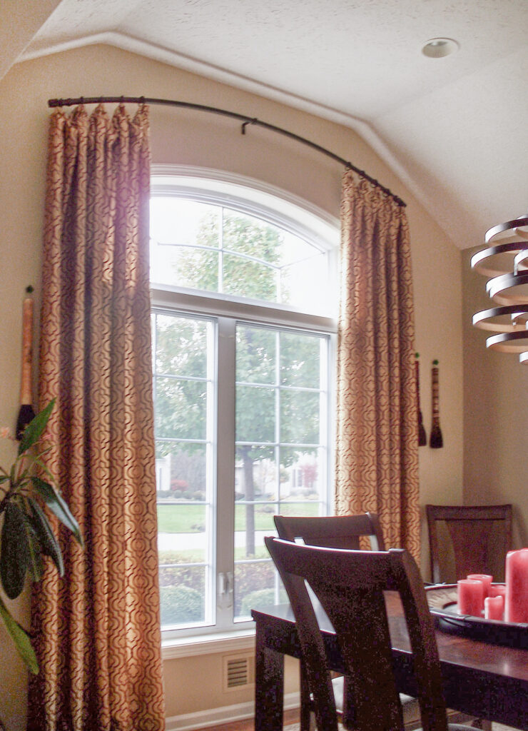 Custom curved drapery rod following dramatic arch for arched window treatment