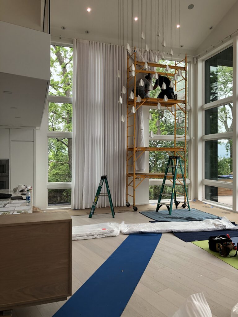 Motorized ripplefold drapery installation for 18-foot ceiling in lakefront home